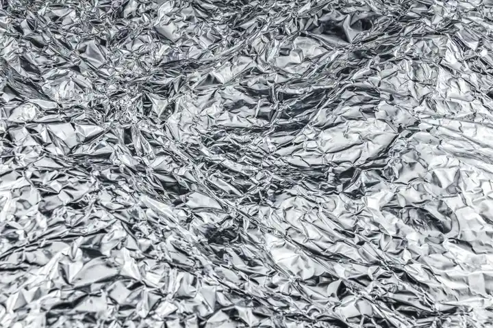 Close-up of crumpled aluminum foil creating a shiny, textured surface.